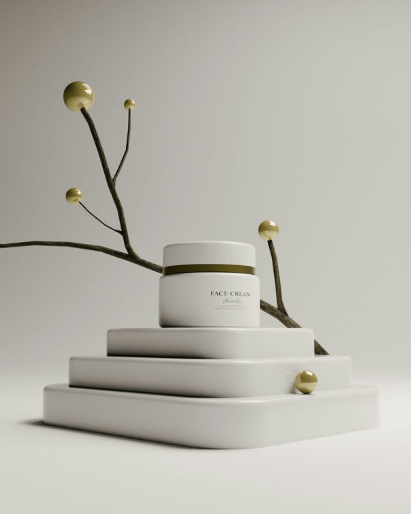 White jar of face cream on stacked plinths with a botanical branch