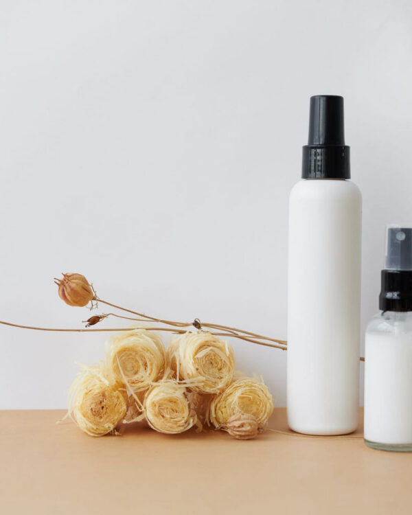 Hydrating Dew Mist White spray bottle beside dried flowers
